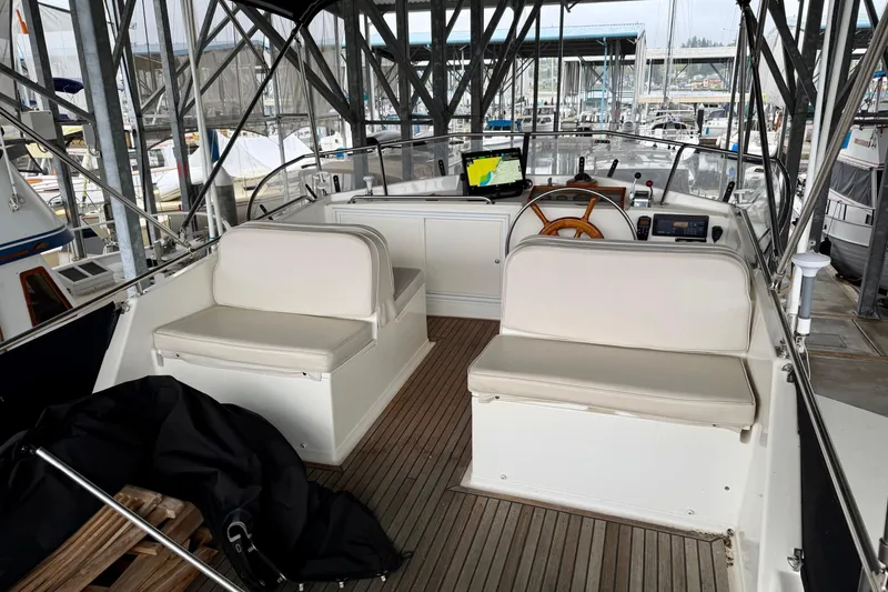 Slide: The Image of 1991 Grand Banks 36 Europa yacht interior with helm, seating, and navigation equipment in marina. - 57