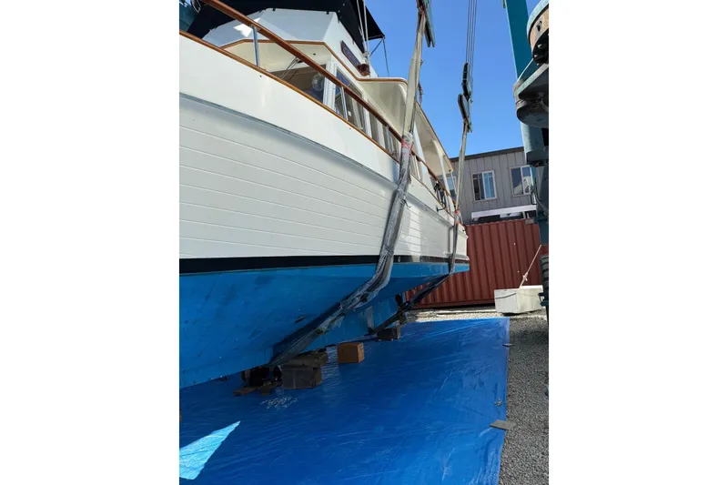 Slide: The Image of 1991 Grand Banks 36 Europa boat on dry dock with blue tarp and lifting straps. - 63