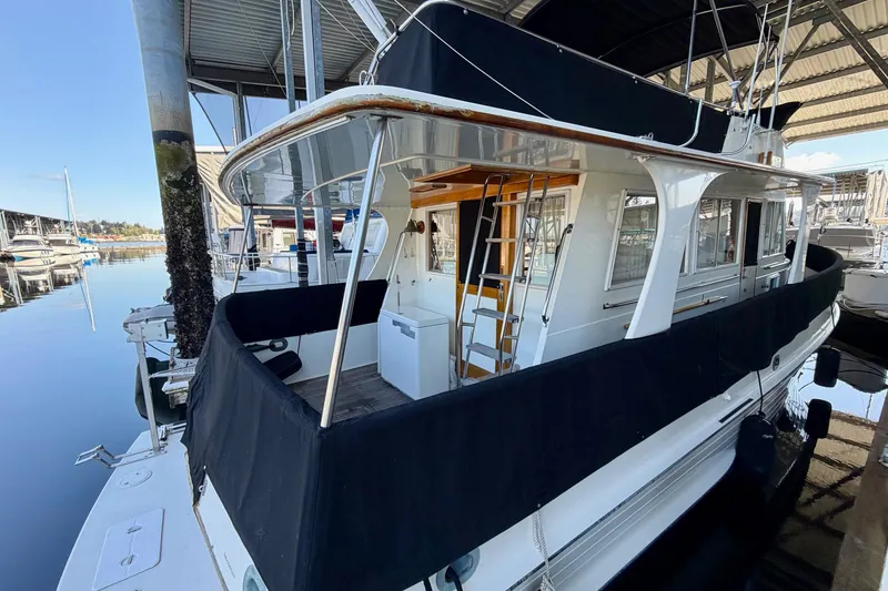 Slide: The Image of 1991 Grand Banks 36 Europa yacht docked in a marina, featuring a covered deck and sleek design. - 8
