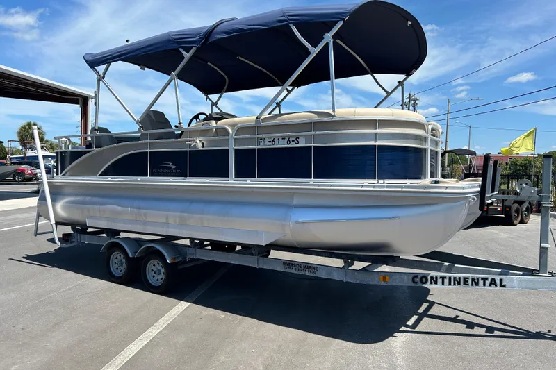 The Image of 2015 Bennington 22 SSX pontoon boat on a trailer under a blue sky. - 1