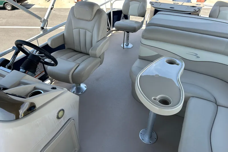 Slide: The Image of 2015 Bennington 22 SSX boat interior with plush seating and steering console. - 11