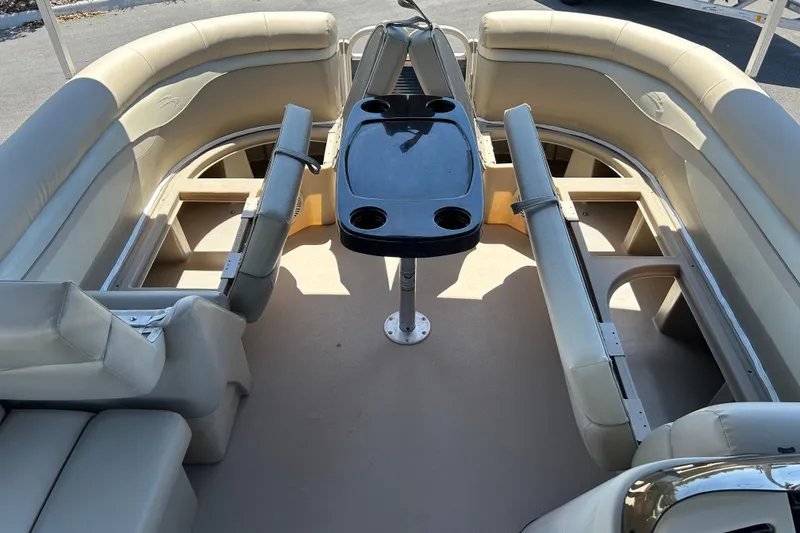 Slide: The Image of 2015 Bennington 22 SSX pontoon boat interior with beige seating and central table. - 14