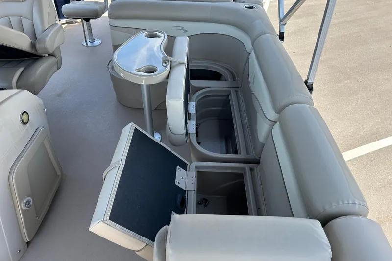 Slide: The Image of 2015 Bennington 22 SSX boat interior with open storage compartments and seating. - 15