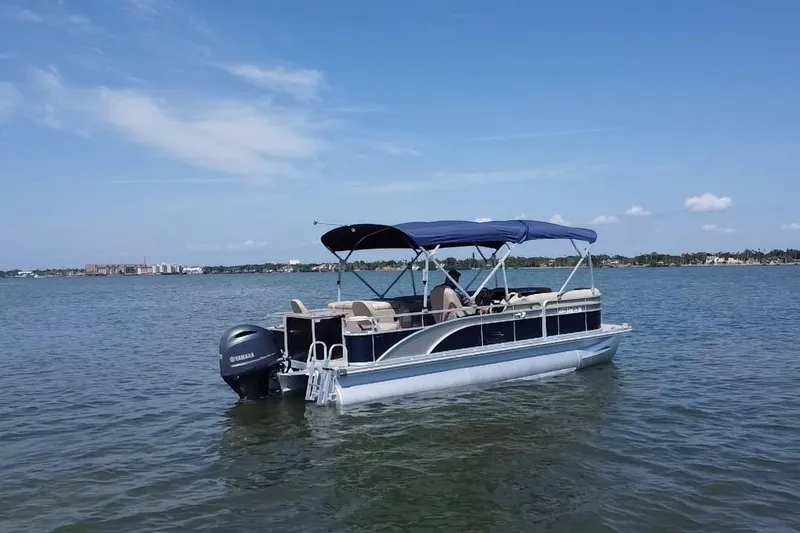 Slide: The Image of 2015 Bennington 22 SSX pontoon boat on calm water under clear blue sky. - 20