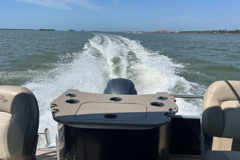 Slide: The Image of Bennington 22 SSX 2015 pontoon boat cruising on open water, leaving a wake behind. - 21