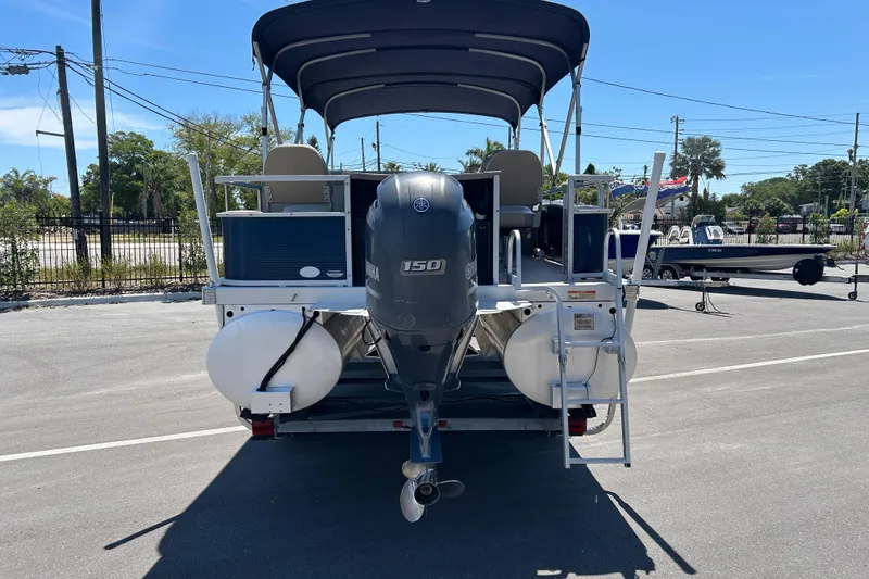 Slide: The Image of 2015 Bennington 22 SSX pontoon boat with Yamaha 150 engine, parked outdoors. - 3