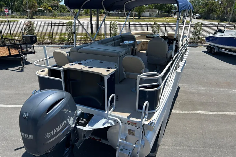 Slide: The Image of 2015 Bennington 22 SSX pontoon boat with Yamaha motor, parked outdoors. - 7
