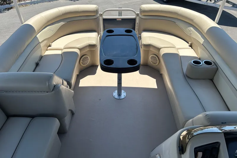 Slide: The Image of 2015 Bennington 22 SSX pontoon boat interior with beige seating and central table. - 8