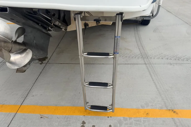 Slide: The Image of Stainless steel ladder on 2000 Chris Craft 262 Sport Deck boat, docked on concrete surface. - 13