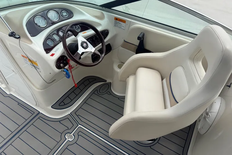 Slide: The Image of 2000 Chris Craft 262 Sport Deck boat interior with steering wheel and captain's chair. - 15