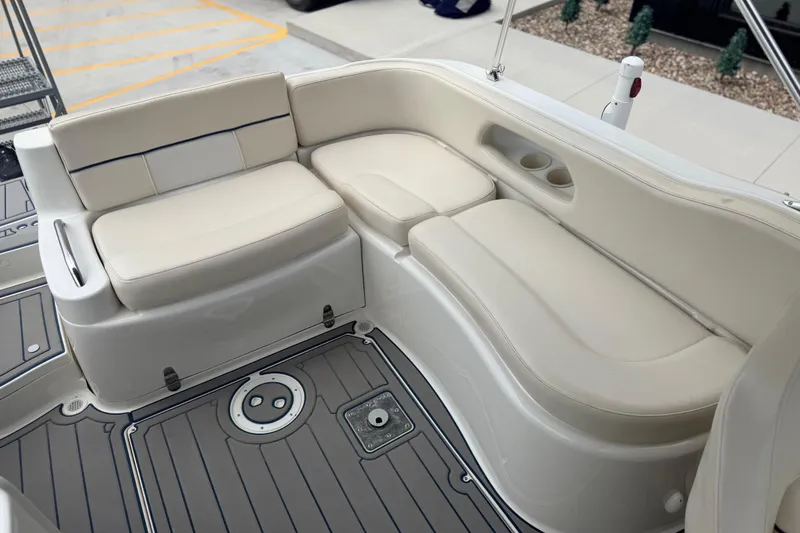Slide: The Image of 2000 Chris Craft 262 Sport Deck boat interior with beige seating and cup holders. - 18