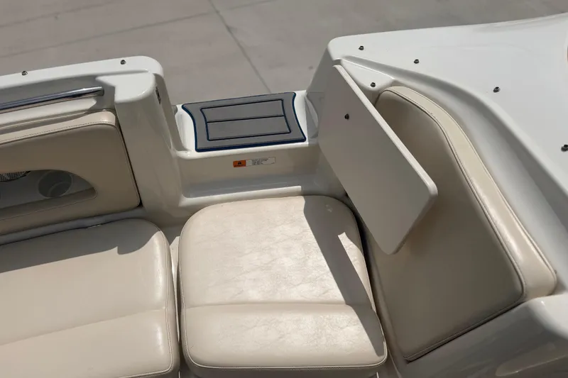 Slide: The Image of Interior seating of a 2000 Chris Craft 262 Sport Deck boat, featuring beige upholstery. - 23