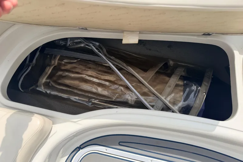 Slide: The Image of Storage compartment on a 2000 Chris Craft 262 Sport Deck boat, containing folded equipment. - 24