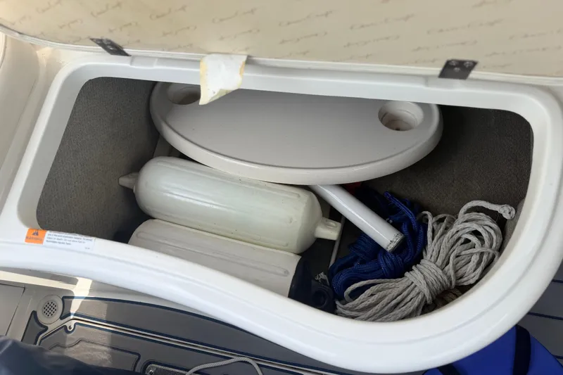 Slide: The Image of Storage compartment in a 2000 Chris Craft 262 Sport Deck boat with ropes and accessories. - 27