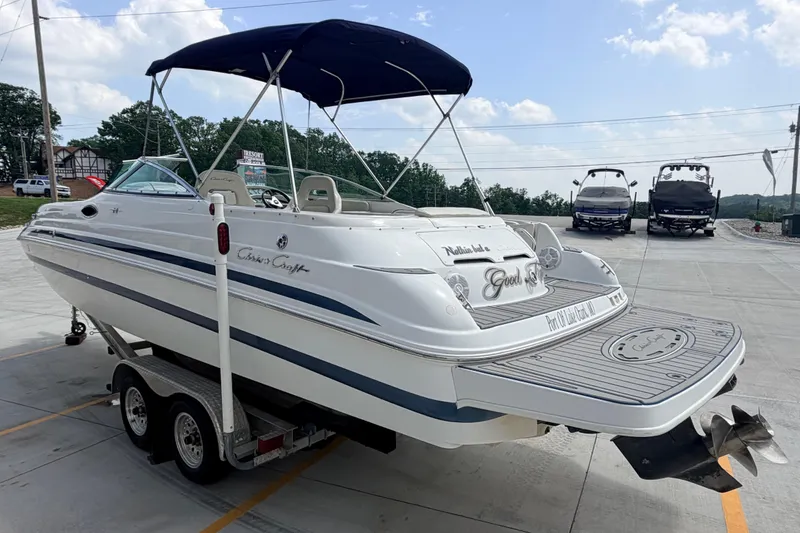 Slide: The Image of 2000 Chris Craft 262 Sport Deck boat on trailer, featuring sleek design and canopy. - 4