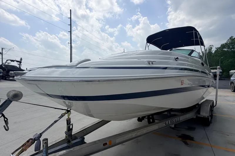 Slide: The Image of 2000 Chris Craft 262 Sport Deck boat on trailer under cloudy sky. - 6