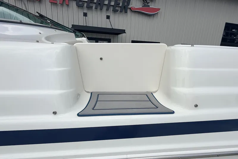 Slide: The Image of 2000 Chris Craft 262 Sport Deck boat with white exterior and blue accents. - 9