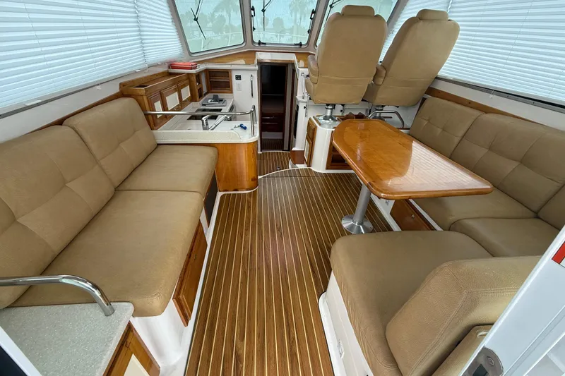 Slide: The Image of Interior of 2011 Back Cove Downeast 37 yacht with seating, table, and helm chairs. - 11