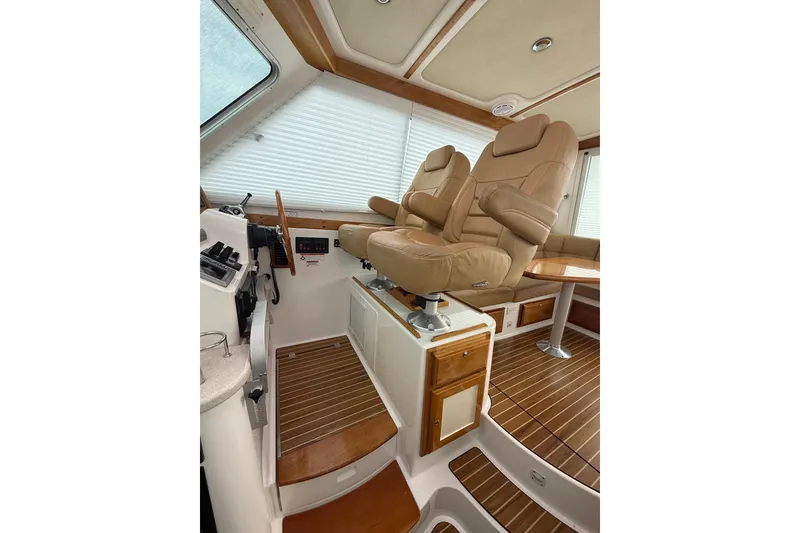 Slide: The Image of Luxurious interior of 2011 Back Cove Downeast 37 with cushioned seating and wooden table. - 12