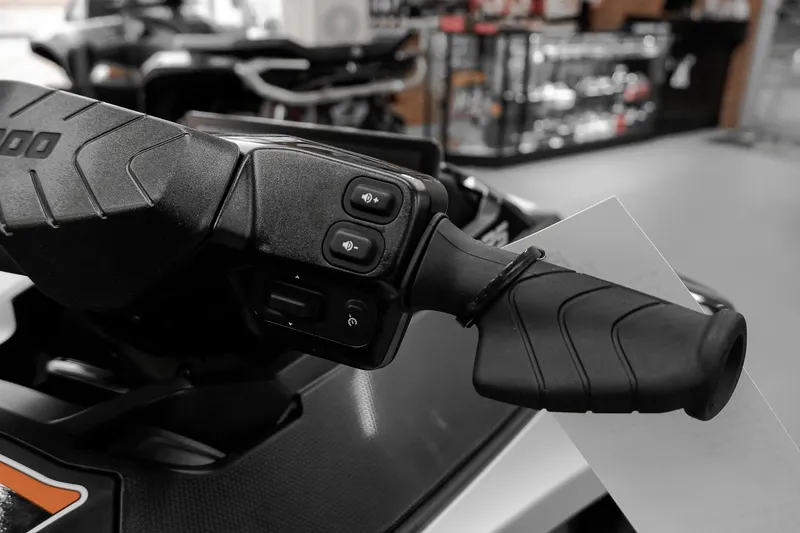 Slide: The Image of Close-up of 2026 Sea-Doo GTX Limited 325 handlebar controls in a showroom. - 13