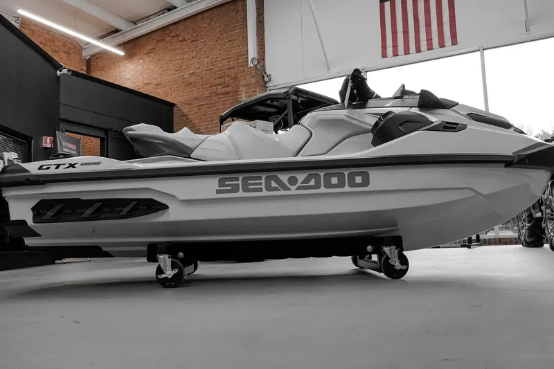 Slide: The Image of 2026 Sea-Doo GTX Limited 325 jet ski displayed indoors with American flag backdrop. - 4