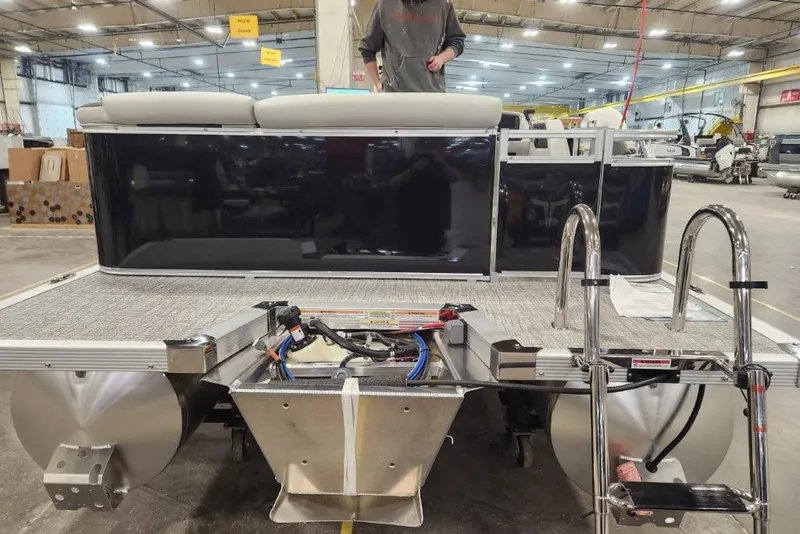 Slide: The Image of 2026 Tahoe Pontoon 1985 LTZ Cruise in a warehouse, showcasing rear deck and ladder. - 10