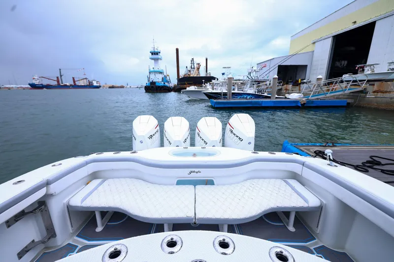 Slide: The Image of 2020 Yellowfin 42 Offshore boat docked, featuring powerful outboard engines and spacious seating. - 18