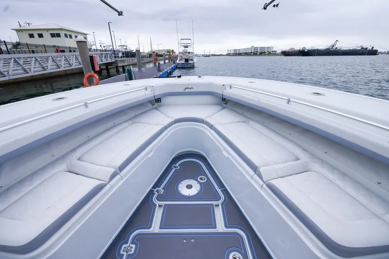Slide: The Image of 2020 Yellowfin 42 Offshore boat interior with cushioned seating at a marina. - 25