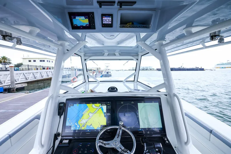 Slide: The Image of Cockpit view of 2020 Yellowfin 42 Offshore boat with navigation screens and steering wheel. - 28