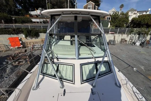 Slide: The Image of 1996 Grady-White Sailfish 272 boat docked, showcasing cabin and sturdy frame. - 10