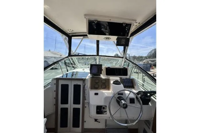 Slide: The Image of 1996 Grady-White Sailfish 272 boat cockpit with steering wheel and navigation equipment. - 13