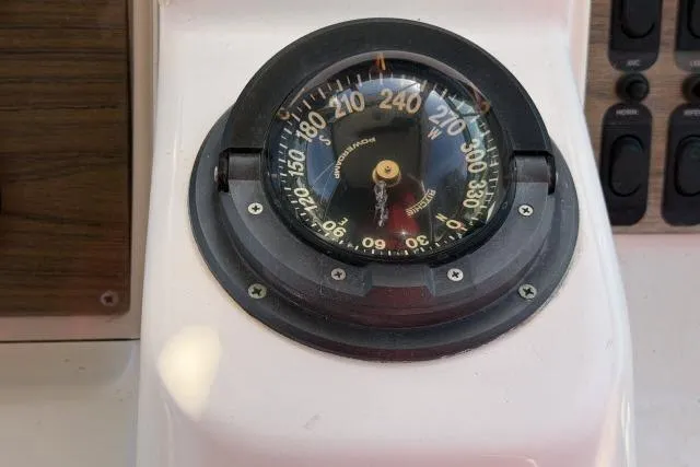 Slide: The Image of Compass on 1996 Grady-White Sailfish 272 boat dashboard, showing navigation directions. - 15