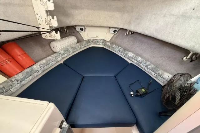 Slide: The Image of 1996 Grady-White Sailfish 272 cabin interior with blue cushions and safety equipment. - 21