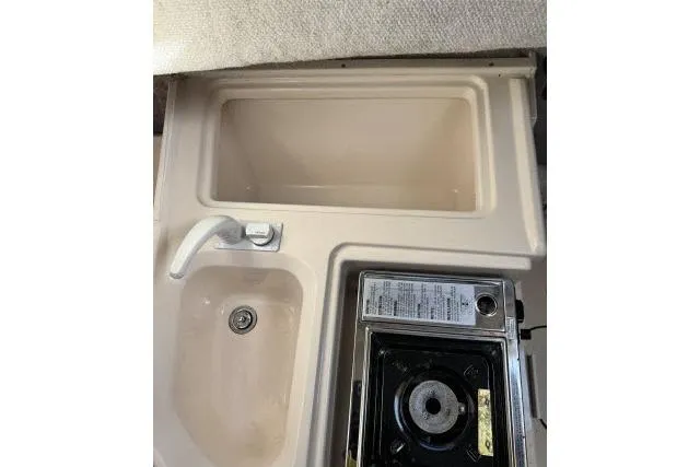 Slide: The Image of 1996 Grady-White Sailfish 272 boat kitchenette with sink and stove. - 23