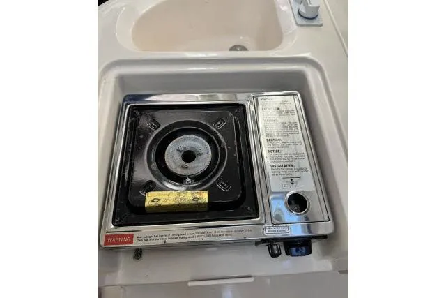 Slide: The Image of Built-in stove on 1996 Grady-White Sailfish 272 boat, featuring safety instructions and control knobs. - 25