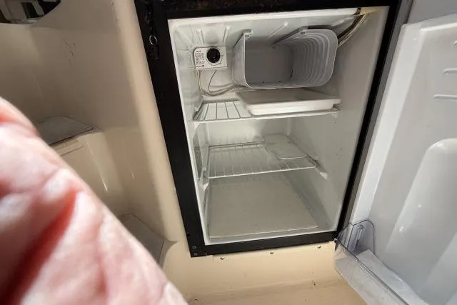 Slide: The Image of Open refrigerator inside a 1996 Grady-White Sailfish 272 boat, showing empty shelves. - 27