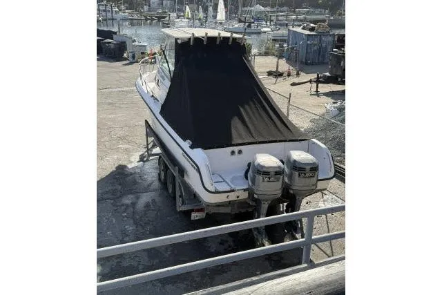 Slide: The Image of 1996 Grady-White Sailfish 272 boat with dual outboard motors, docked at a marina. - 6