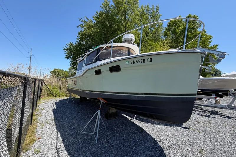 Slide: The Image of 2018 Ranger Tugs R-27 boat on stands, parked outdoors on gravel. - 1