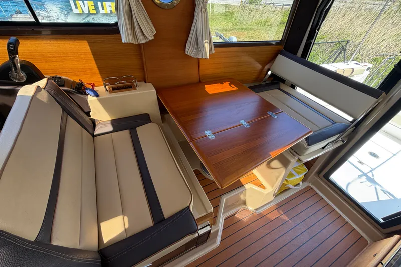 Slide: The Image of Interior of 2018 Ranger Tugs R-27 with foldable wooden table and cushioned seating. - 10