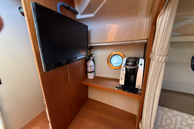 Slide: The Image of 2018 Ranger Tugs R-27 interior with TV, coffee maker, and fire extinguisher. - 14