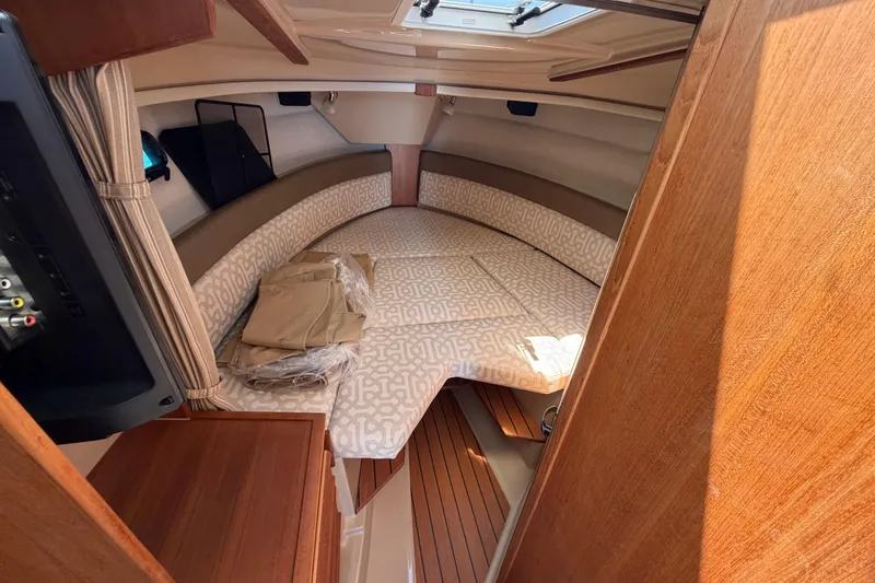 Slide: The Image of Cozy cabin interior of 2018 Ranger Tugs R-27 with patterned bedding and wood accents. - 15