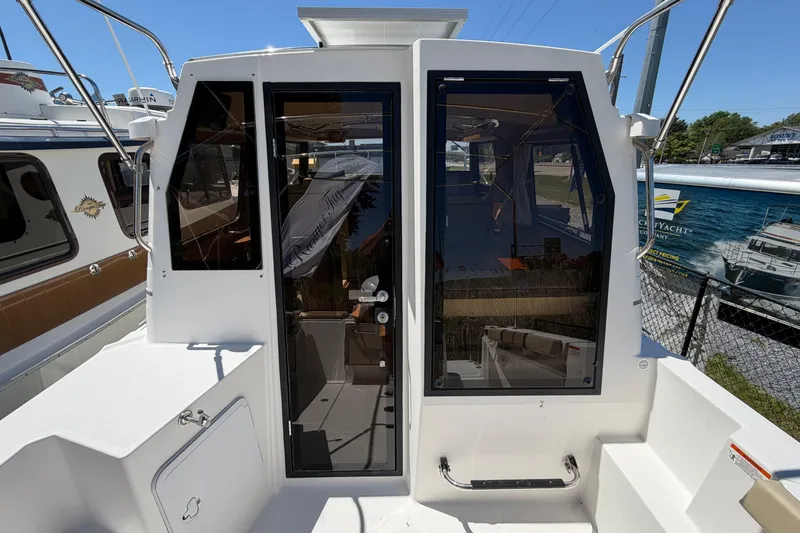 Slide: The Image of 2018 Ranger Tugs R-27 boat exterior with glass doors and visible interior. - 5