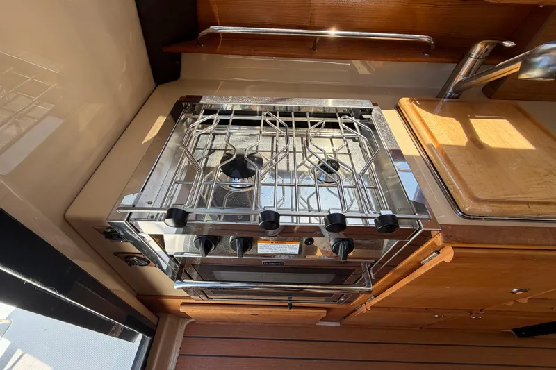 Slide: The Image of Compact kitchen area in a 2018 Ranger Tugs R-27 boat with stove and sink. - 7