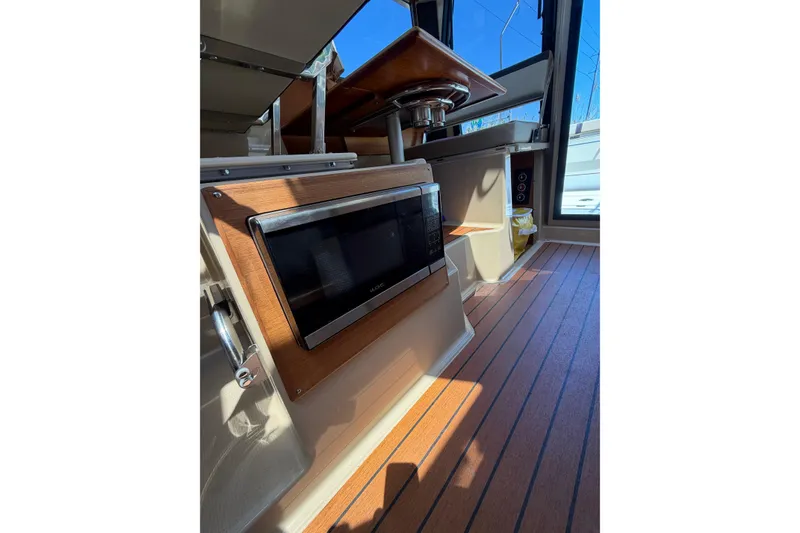 Slide: The Image of Interior of 2018 Ranger Tugs R-27 with wood flooring and built-in microwave. - 9