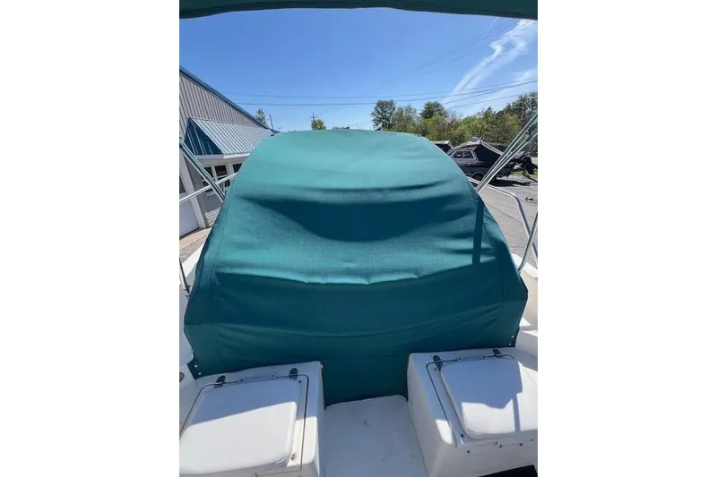 Slide: The Image of 2001 Seapro 235 WAC boat with teal cover, outdoor setting. - 12