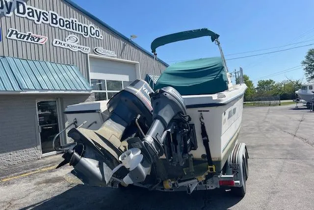 Slide: The Image of 2001 Seapro 235 WAC boat on trailer outside dealership, featuring dual outboard motors. - 14