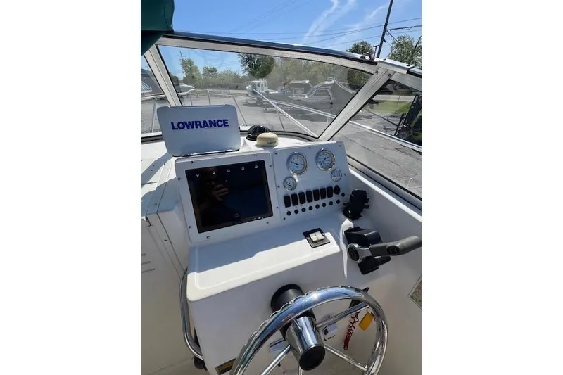 Slide: The Image of 2001 Seapro 235 WAC boat dashboard with Lowrance navigation system and steering wheel. - 4