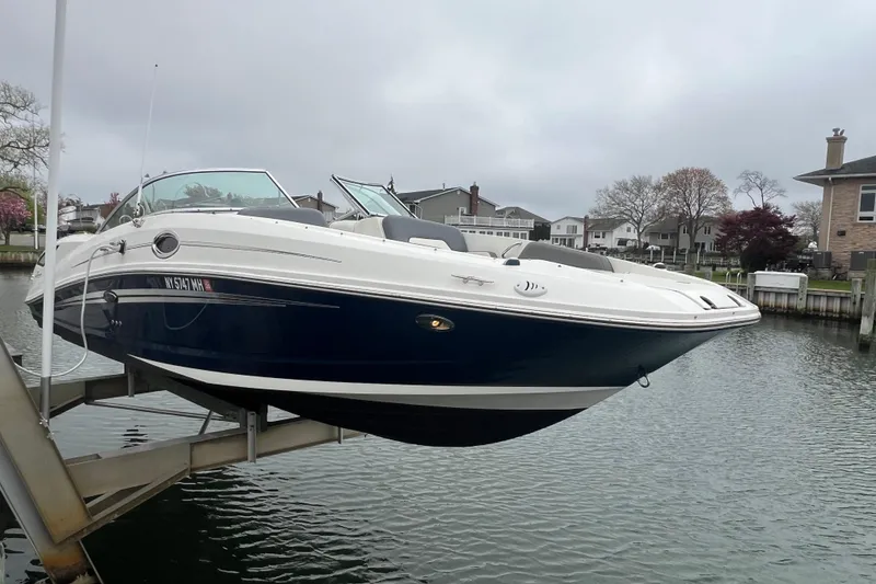 Slide: The Image of 2011 Sea Ray 300 Sundeck boat docked by waterfront homes. - 2