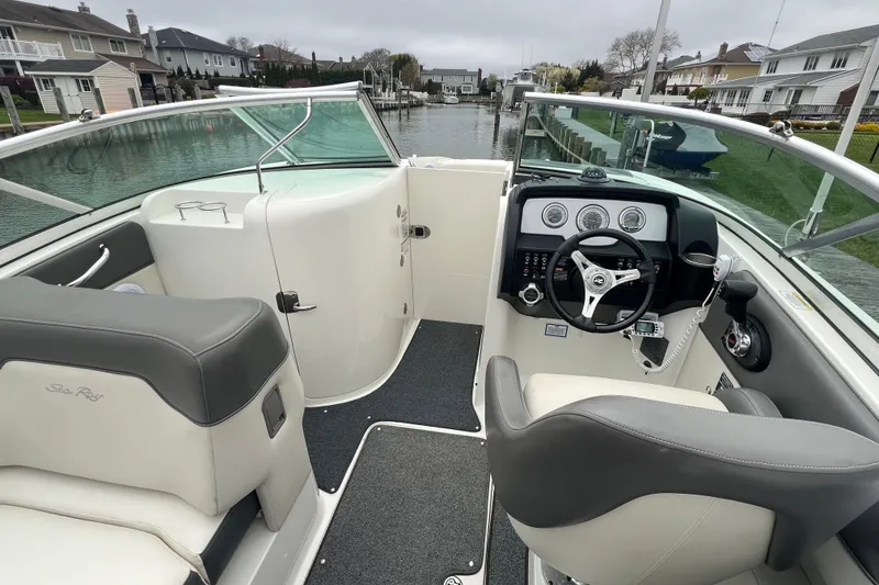 Slide: The Image of 2011 Sea Ray 300 Sundeck interior with steering wheel and seating, docked in a canal. - 4