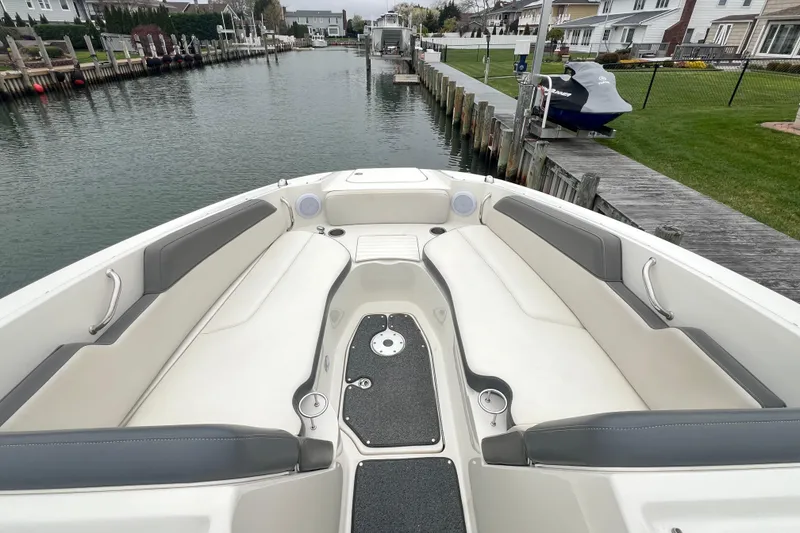 Slide: The Image of 2011 Sea Ray 300 Sundeck boat interior with spacious seating, docked by a canal. - 5